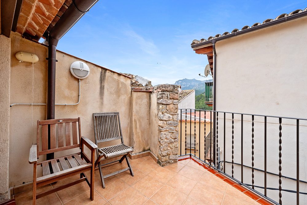 La terrasseta amb cadires de fusta i la muntanya al fons